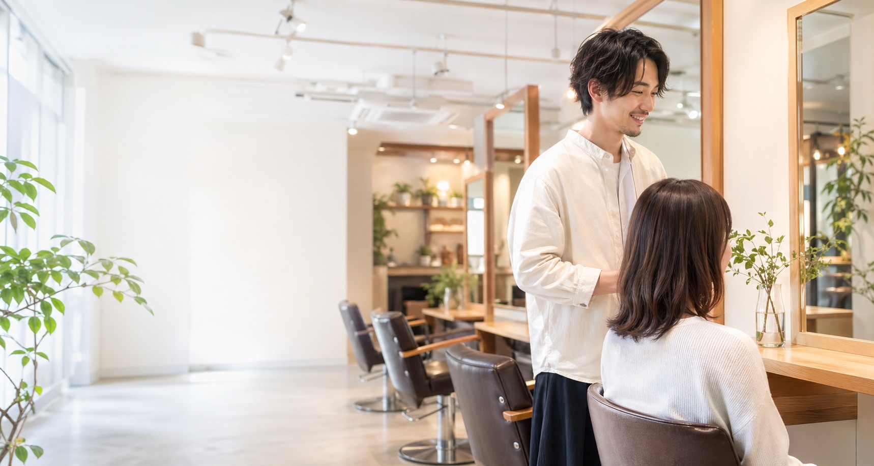 明るい美容室でスタイリストがカウンセリングをしているイメージ